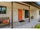 Welcoming front porch with a striking orange door, sleek windows, and cozy seating area at 2708 Fort Worth St, Sarasota, FL 34231