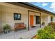 Inviting front porch with a colorful front door, bench seating, and well-manicured landscaping at 2708 Fort Worth St, Sarasota, FL 34231