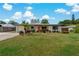 Charming single-story home featuring a well-manicured lawn, colorful landscaping, and a bright orange front door at 2708 Fort Worth St, Sarasota, FL 34231