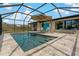 Beautiful in-ground pool inside screened enclosure with travertine tile surround and plenty of seating at 2708 Fort Worth St, Sarasota, FL 34231