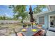 Charming backyard with patio table, black umbrella, and well-manicured lawn, perfect for outdoor entertaining and relaxation at 2932 Upper Tangelo Dr, Sarasota, FL 34239