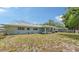 Backyard featuring a covered patio, play-set, and well-manicured lawn, perfect for outdoor activities and relaxation at 2932 Upper Tangelo Dr, Sarasota, FL 34239