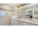 Modern bathroom featuring double sinks, quartz countertops, a frameless shower, and elegant tile work at 2932 Upper Tangelo Dr, Sarasota, FL 34239