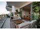 Stylish balcony with comfortable seating and glass railings overlooking city views and plants throughout at 301 Quay Commons # 503, Sarasota, FL 34236