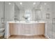 Modern bathroom with a double vanity, light wood cabinets, glass-enclosed shower and light walls at 301 Quay Commons # 503, Sarasota, FL 34236