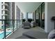 Relaxing balcony seating area with stylish furniture, offering views of the pool and high-rise building at 301 Quay Commons # 611, Sarasota, FL 34236