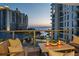 Inviting outdoor balcony seating area with views of the water, buildings, and the city skyline at 301 Quay Commons # 611, Sarasota, FL 34236
