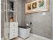 Contemporary bathroom with sleek toilet, stylish drawers, gray patterned wallpaper, and unique decor at 301 Quay Commons # 611, Sarasota, FL 34236