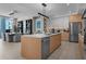 Bright, modern kitchen with stainless appliances, wooden cabinets and island, plus adjacent dining area at 301 Quay Commons # 611, Sarasota, FL 34236