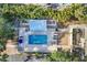 Aerial view of a community pool with lounge seating, a shade structure, and palm trees at 3350 S Osprey Ave # 211A, Sarasota, FL 34239