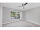 Bedroom with ceiling fan, plush carpet, and a large window providing lots of natural light at 3350 S Osprey Ave # 211A, Sarasota, FL 34239
