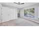 Bedroom with ceiling fan, plush carpet, closet, and window overlooking the outdoor area at 3350 S Osprey Ave # 211A, Sarasota, FL 34239