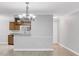 Open dining area with modern chandelier and tiled floor next to the kitchen breakfast bar at 3350 S Osprey Ave # 211A, Sarasota, FL 34239