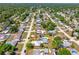 Aerial view of a neighborhood with a house featuring a light gray roof surrounded by green trees at 3427 Cambridge Dr, Sarasota, FL 34232
