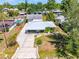 Aerial view of single-story home showcasing well manicured lawn, long driveway, and nearby pool at 3427 Cambridge Dr, Sarasota, FL 34232