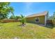 Green backyard featuring ample lawn space and mature tropical foliage and wooden fencing at 3427 Cambridge Dr, Sarasota, FL 34232