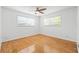 Bright bedroom featuring hardwood floors, a ceiling fan, and a large window at 3427 Cambridge Dr, Sarasota, FL 34232