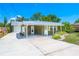 Charming one-story home with a metal roof, carport, and neatly landscaped front yard on a sunny day at 3427 Cambridge Dr, Sarasota, FL 34232