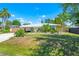 Well-kept home with mature landscaping, a metal roof, and a covered carport for easy parking at 3427 Cambridge Dr, Sarasota, FL 34232