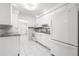 Clean kitchen with white cabinets, white appliances, and tile flooring at 3427 Cambridge Dr, Sarasota, FL 34232