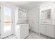 Functional laundry area equipped with a stacked washer and dryer, and a built in sink at 3427 Cambridge Dr, Sarasota, FL 34232