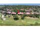 Golf-side villa complex with lush landscaping, mature trees, and red tile roofs, situated with distant water views at 3500 El Conquistador Pkwy # 117, Bradenton, FL 34210