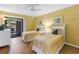 Yellow painted bedroom featuring two twin beds, closet, and sliding door to the outside at 3500 El Conquistador Pkwy # 117, Bradenton, FL 34210