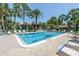 Community swimming pool surrounded by palm trees and lounge chairs, great for relaxation at 3500 El Conquistador Pkwy # 117, Bradenton, FL 34210