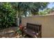 Exterior view of a private courtyard with a bench, gated access, and lush landscaping for outdoor relaxation at 3500 El Conquistador Pkwy # 117, Bradenton, FL 34210