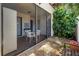 Inviting screened-in patio with comfortable seating, a small table, and views of the landscaped outdoor area at 3500 El Conquistador Pkwy # 117, Bradenton, FL 34210