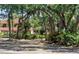 Exterior view of a home surrounded by lush greenery and trees in a neighborhood with private streets at 3500 El Conquistador Pkwy # 117, Bradenton, FL 34210