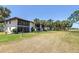Condominium exterior showing meticulously maintained grounds with palm trees and a golf course view at 3500 El Conquistador Pkwy # 117, Bradenton, FL 34210