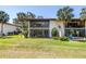 Exterior view of the condominium featuring a well-manicured lawn and beautiful landscaping at 3500 El Conquistador Pkwy # 117, Bradenton, FL 34210