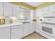 Bright kitchen with white cabinets and appliances, and a tile backsplash at 3500 El Conquistador Pkwy # 117, Bradenton, FL 34210
