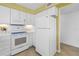 Bright kitchen features white cabinets, appliances, and tile flooring at 3500 El Conquistador Pkwy # 117, Bradenton, FL 34210