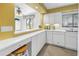 Bright kitchen features white cabinets, countertop seating, and yellow accent wall at 3500 El Conquistador Pkwy # 117, Bradenton, FL 34210