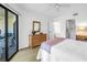 Bright bedroom with wood-look floors, dresser, and sliding glass door with balcony access at 3500 El Conquistador Pkwy # 117, Bradenton, FL 34210