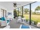 Enclosed lanai featuring a ceiling fan, comfortable seating, and stunning golf course views at 3500 El Conquistador Pkwy # 117, Bradenton, FL 34210