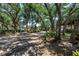 Street view of houses nestled in a neighborhood with mature trees and lush landscaping along private streets at 3500 El Conquistador Pkwy # 117, Bradenton, FL 34210