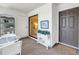 Sunroom featuring comfortable seating and a display case, transitioning to a bedroom and a door to the outside at 3500 El Conquistador Pkwy # 117, Bradenton, FL 34210