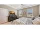 This bedroom features carpet, bright windows, a dresser with a TV, and a comfortable bed at 3803 Savanna Palms Ct, Bradenton, FL 34211