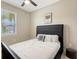 This bedroom features carpet, a bright window, a modern poster, and a comfortable queen size bed at 3803 Savanna Palms Ct, Bradenton, FL 34211