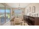 Bright dining room with elegant chandelier, sliding glass doors to the backyard, and stylish furniture at 3803 Savanna Palms Ct, Bradenton, FL 34211