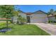 Inviting single-story home with a brick paver driveway, lush green lawn, and beautiful palm trees at 3803 Savanna Palms Ct, Bradenton, FL 34211