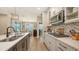 Well-lit kitchen with island seating, stainless appliances, and a clear view into the dining area at 3803 Savanna Palms Ct, Bradenton, FL 34211