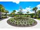 Beautiful landscaping with palm trees and a central flower bed at 3803 Savanna Palms Ct, Bradenton, FL 34211