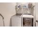 The laundry room features a modern, front-loading washer and dryer with shelving at 3803 Savanna Palms Ct, Bradenton, FL 34211
