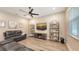 Inviting living room featuring wood-look flooring, neutral decor, and a large flat-screen TV at 3803 Savanna Palms Ct, Bradenton, FL 34211