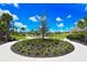 Landscaped community park and playground featuring a circular flower bed and various recreational activities at 3803 Savanna Palms Ct, Bradenton, FL 34211