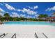 Spacious community pool with a white tiled deck and lounge chairs for sunbathing at 3803 Savanna Palms Ct, Bradenton, FL 34211